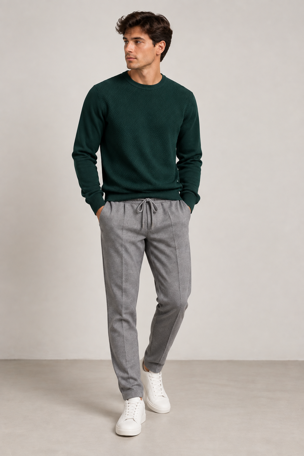 Uomo con maglione verde e pantalone grigio